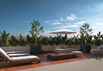 Solário do Baker’s Bay Residence com espreguiçadeiras, ombrelone e vegetação